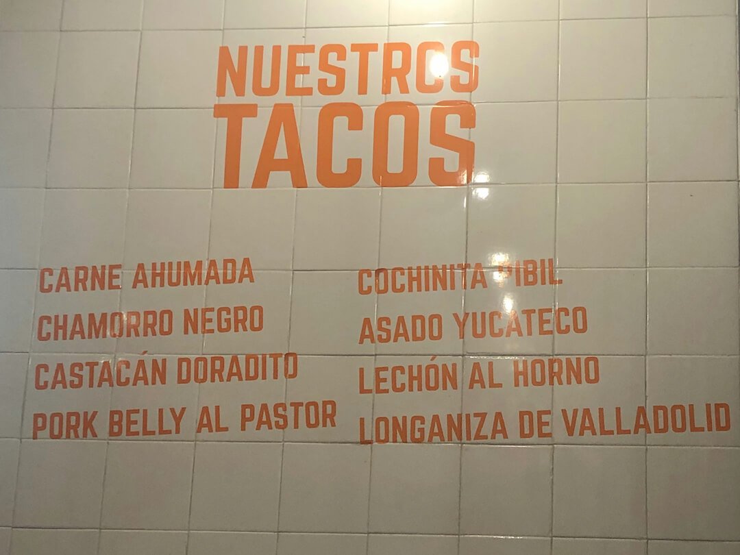 A list of menu items on the wall at Taqueria de la Union