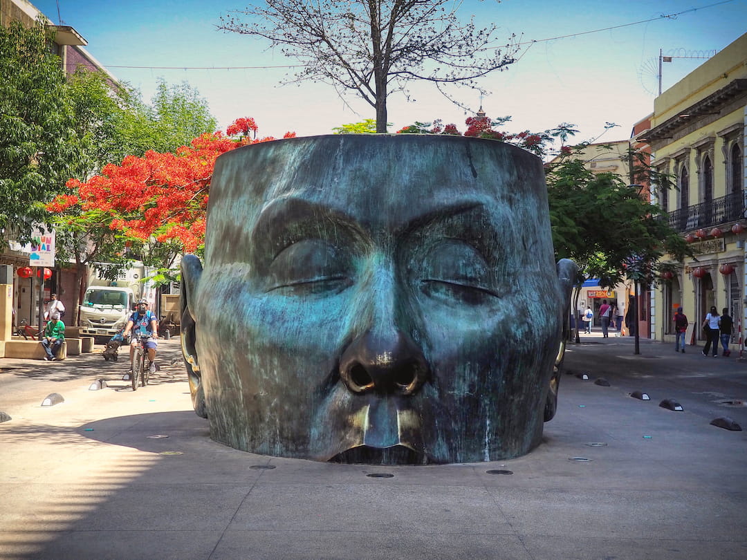Sculpture of a head in the middle of a road