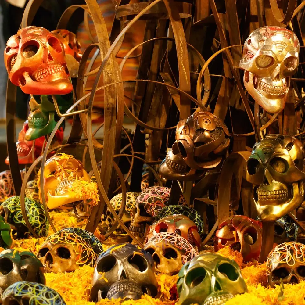 Day of the Dead display in Oaxaca Mexico A metal display featuring skulls of different colours and orange marigolds