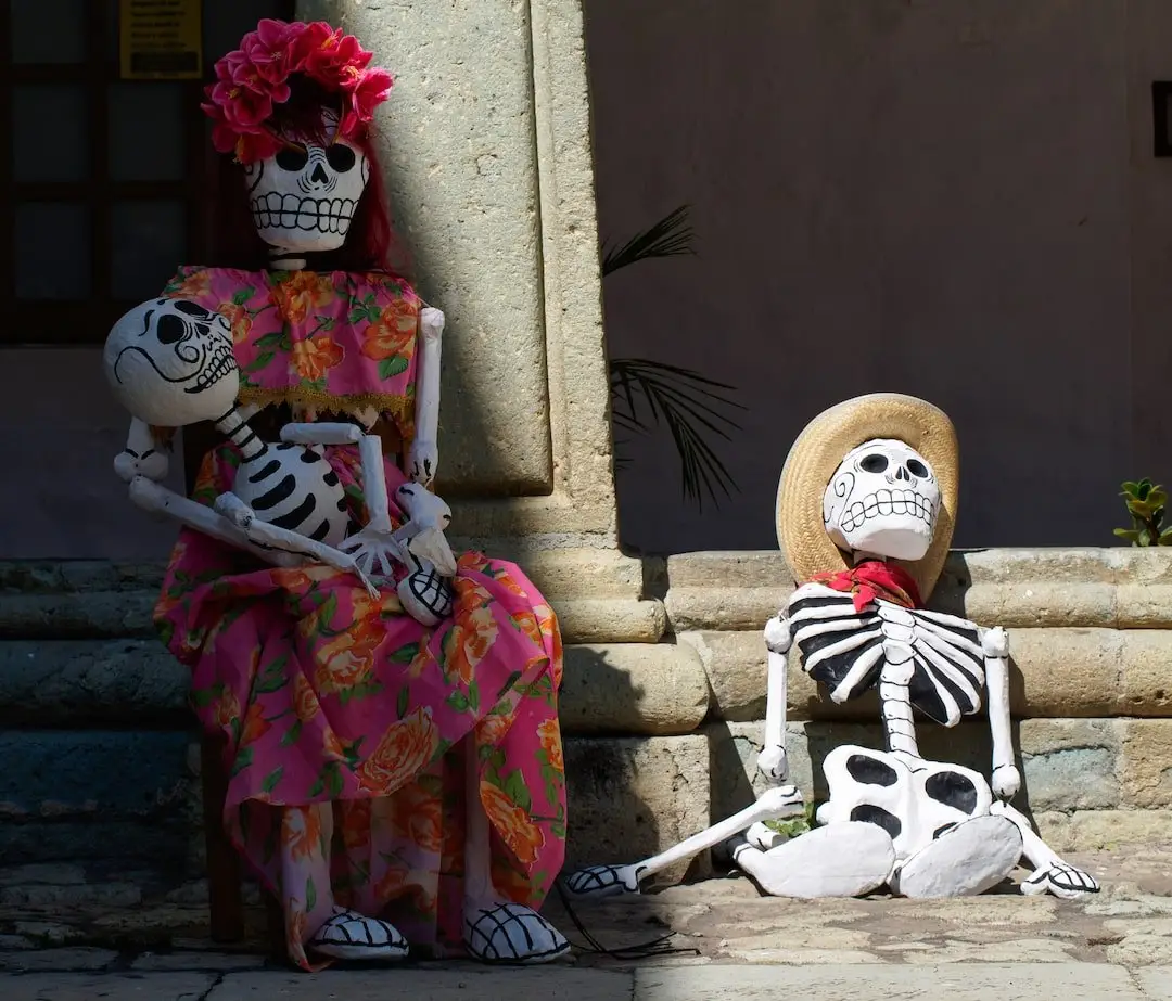 Day of the Dead skeletons - Oaxaca - Mexico A skeletal mother is seated holding a skeleton of a child, while a skeletal father sits on the ground beside her