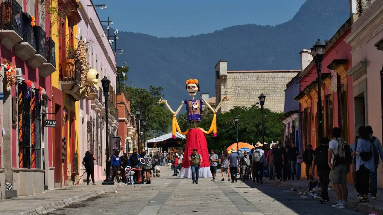 Mojiganga in Oaxaca Mexico A giant puppet stands with arms raised in a Oaxaca street