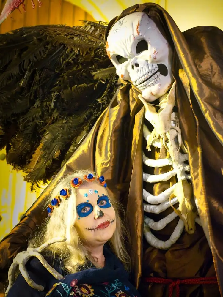 Nicky with face paint poses in Oaxaca Nicky in face paint alongside a very tall skeleton