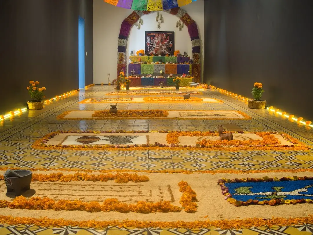 Public ofrenda in Puebla Mexico A public ofrenda with lots of sand art and magnolias laid out in front of it