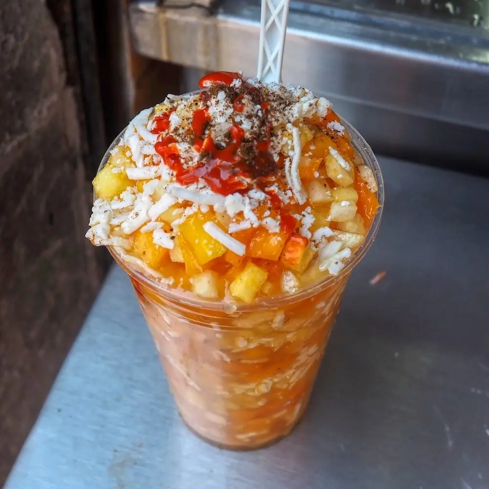 Gazpacho Moreliano - Morelia - Michoacan A plastic cup filled with fruit and orange juice