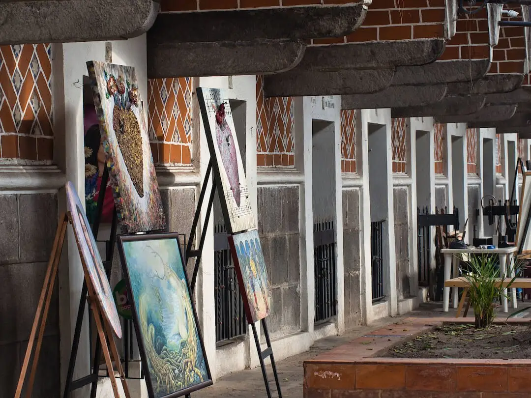 Barrio del Artista Puebla - Mexico A row of small red-tiled studios with paintings on display
