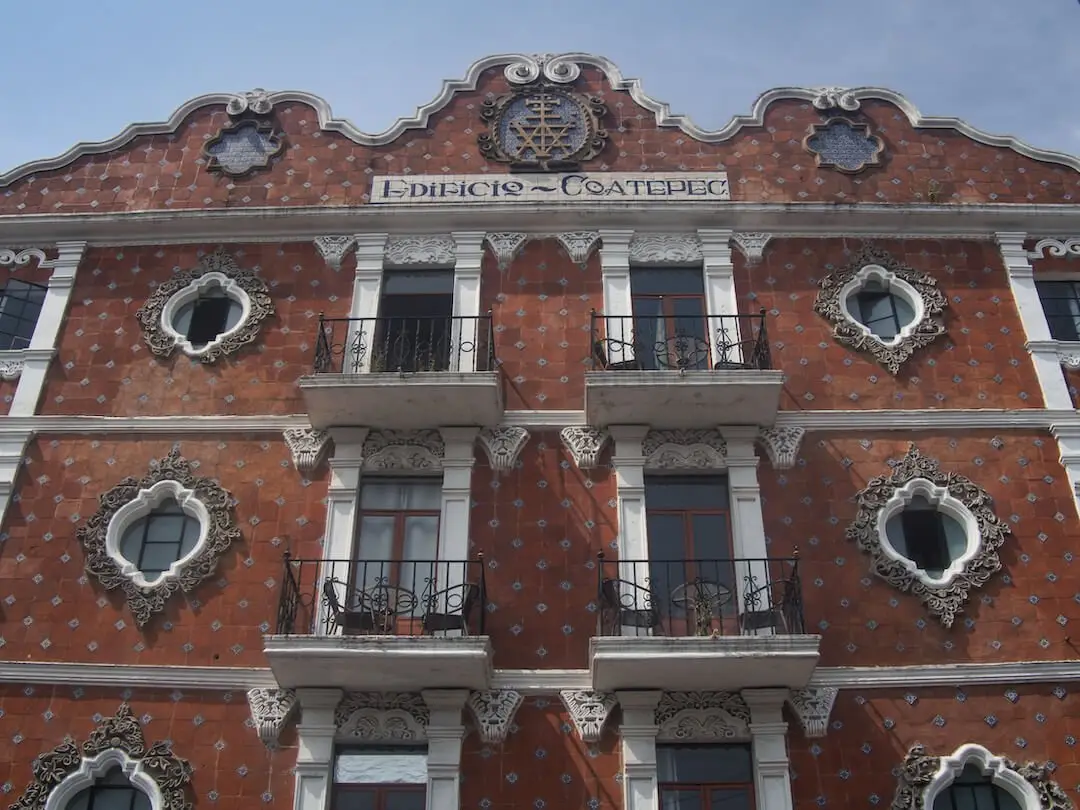 Edificio Coatepec Cholula A building with a facade covered in red tiles