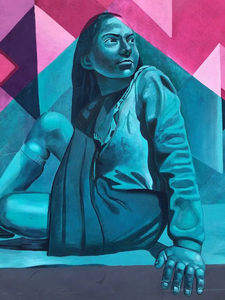 Mural de la Esperenza al Porevnir Puebla Mexico Painting of a seated blue-coloured female looking behind her