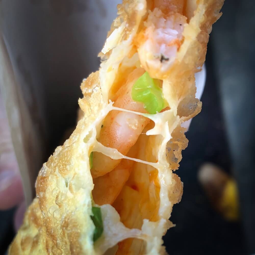 A pastel filled with prawns, cheese and onion