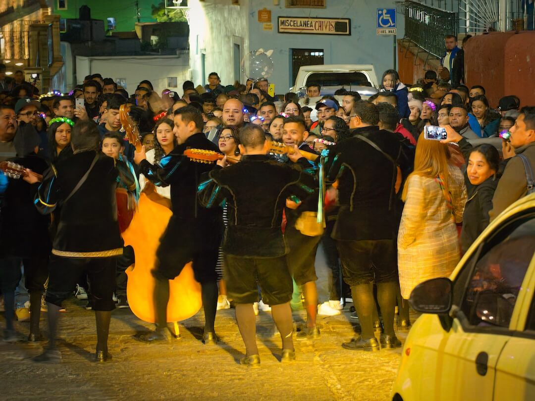 A road is blocked by a group of musicians and its audience
