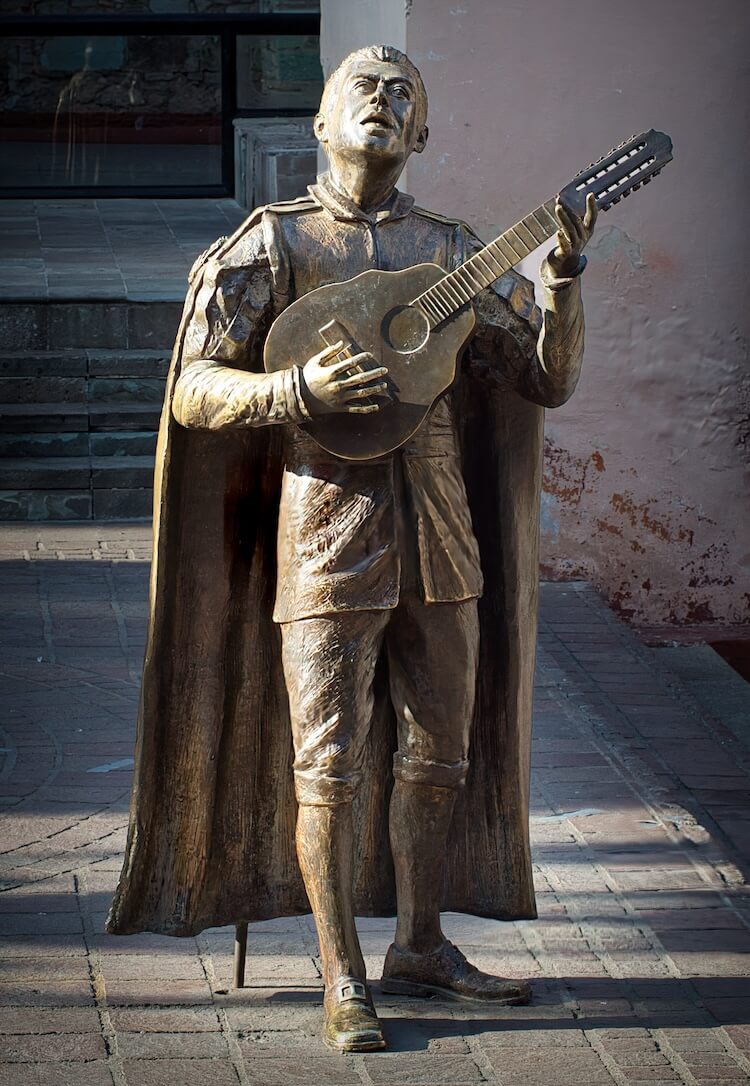 A statue of a man playing a guitar-like instrument