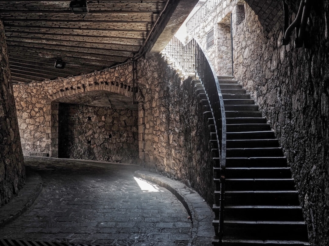 A staircase leads out of a stone tunnel