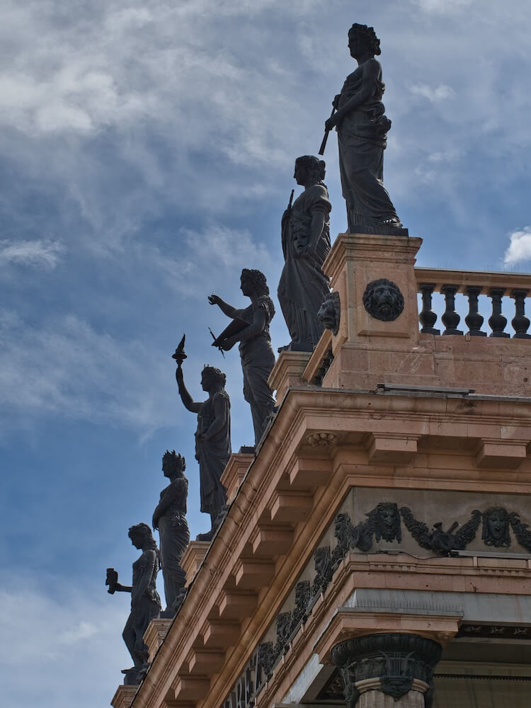 A building with six bronze statues on its roof