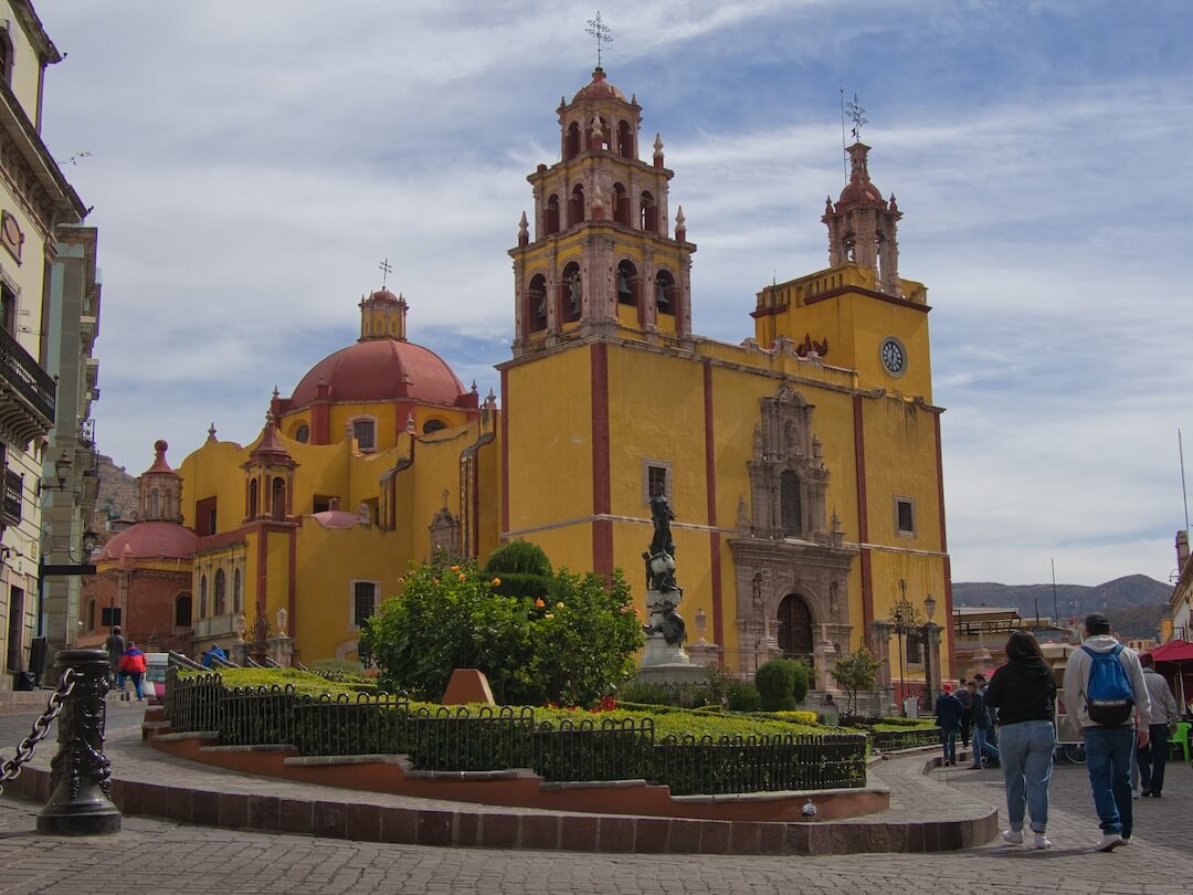  A yellow church with a red dome on a town square