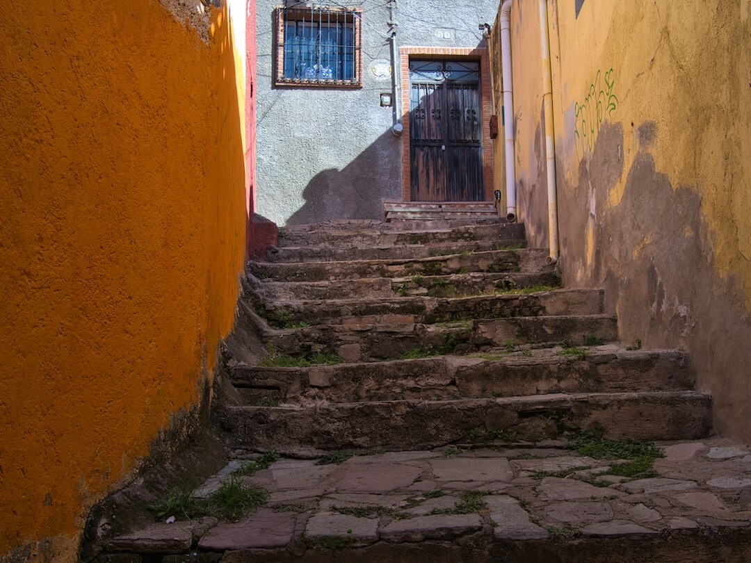 A stepped alleyway with orange and blue walls on either side