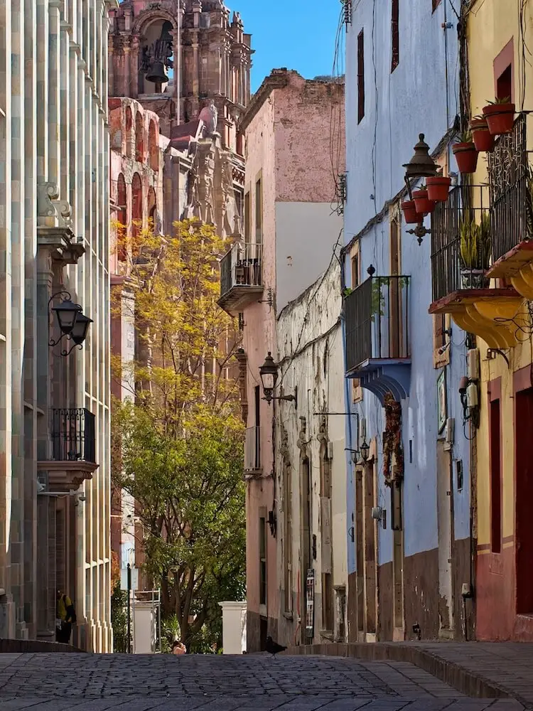 A narrow street with tall buildings on either side