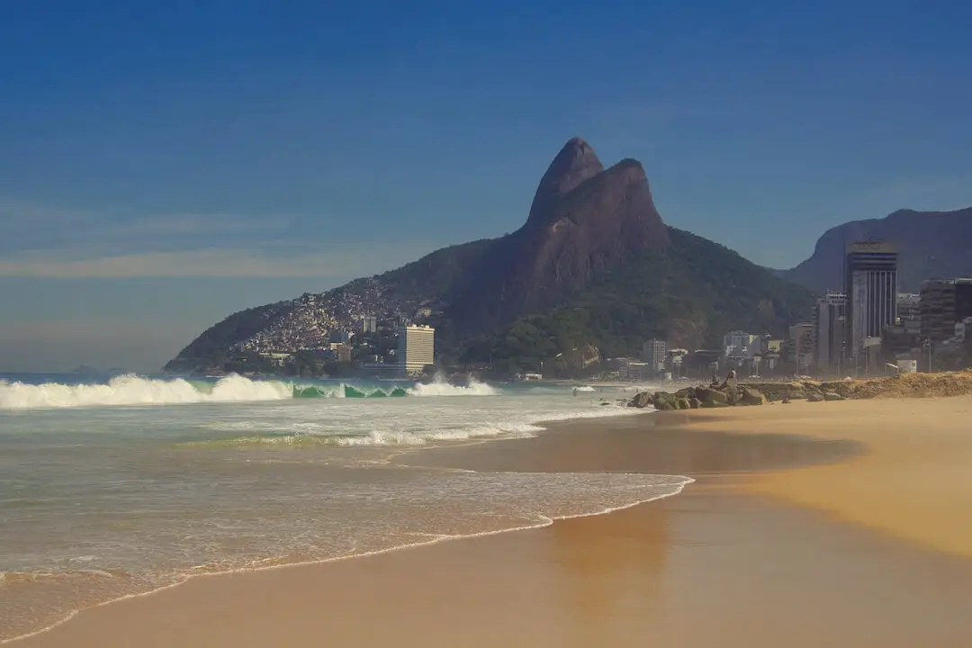 An empty beach with a mountain behind that had two peaks