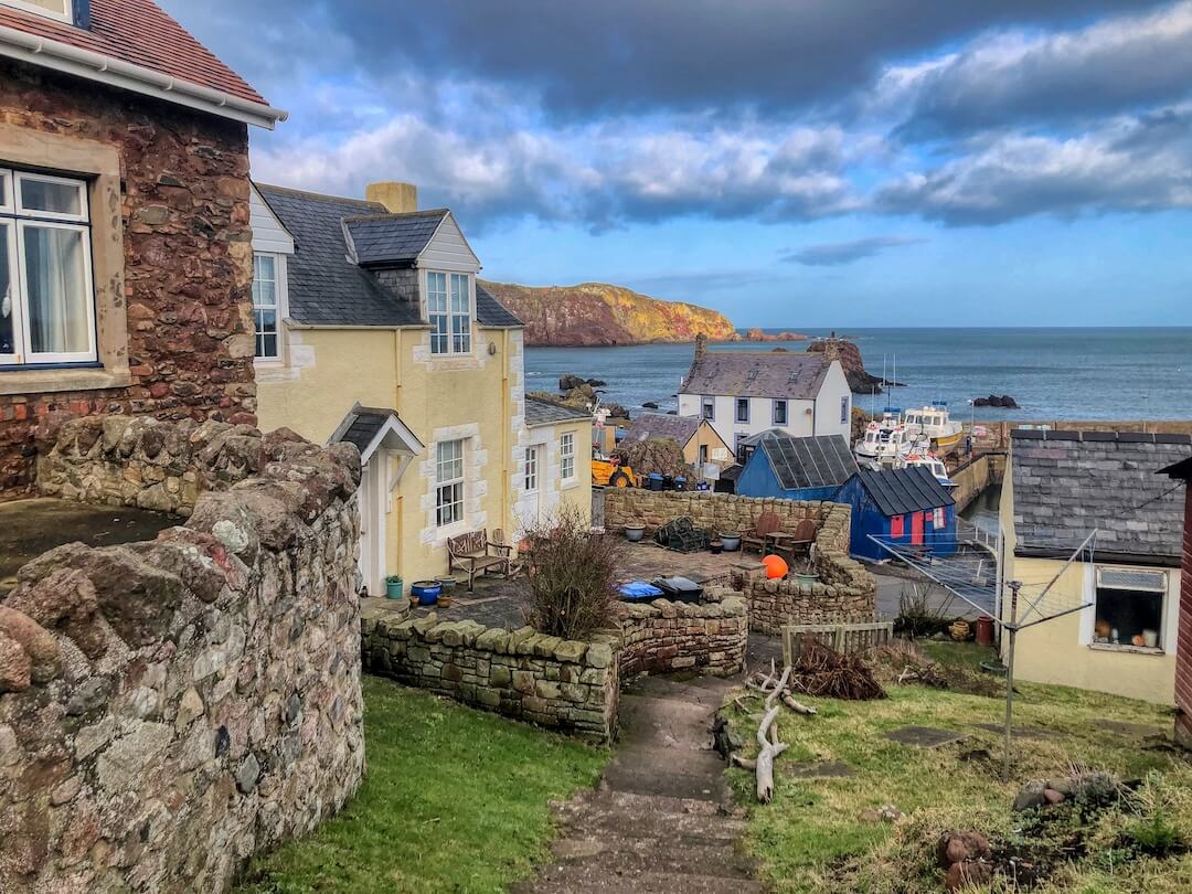 Stone cottages lead down to a harbour 
