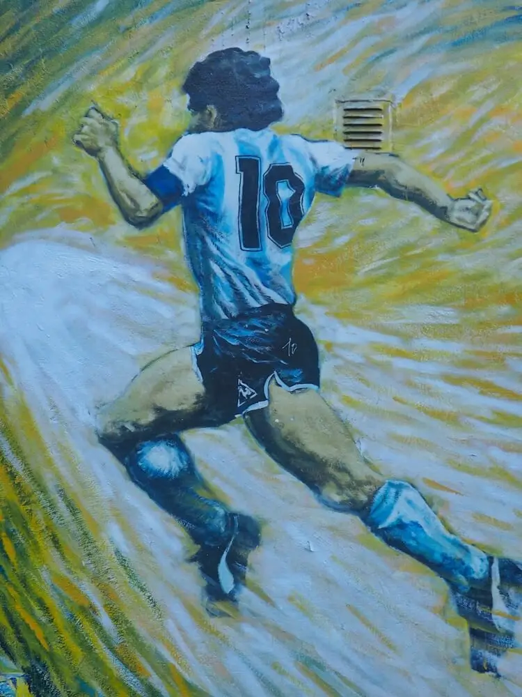 Street art - a running footballer in Argentina colours against a yellow and white background