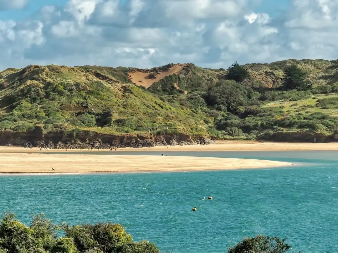 Padstow - Rock - Cornwall A spit of sand sits between the sea and green hills in the background