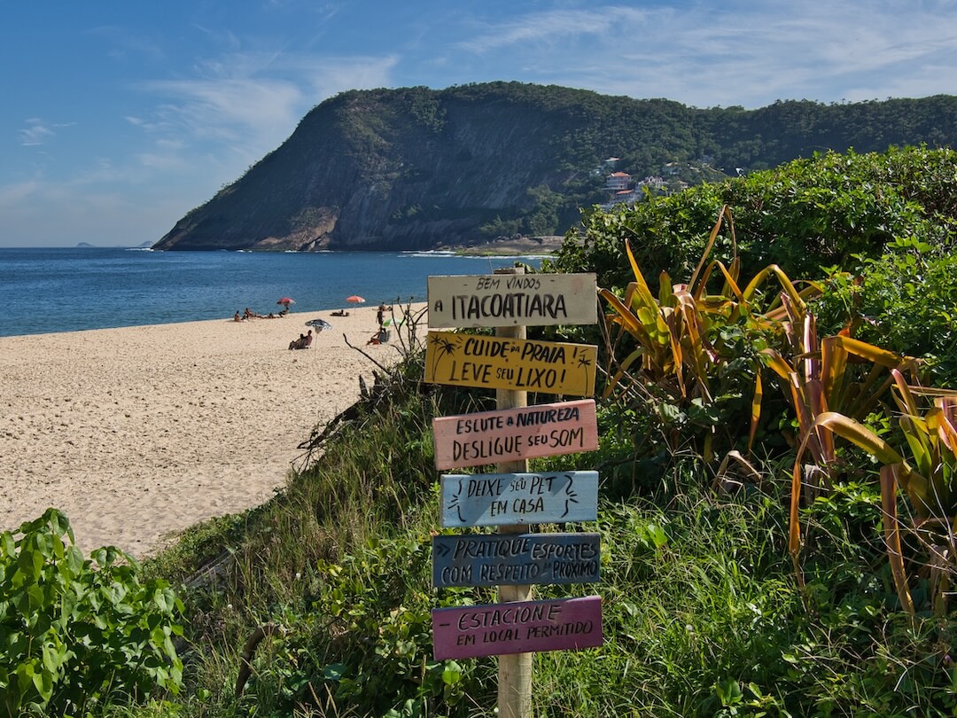 A multi-coloured signpost leads to a beach