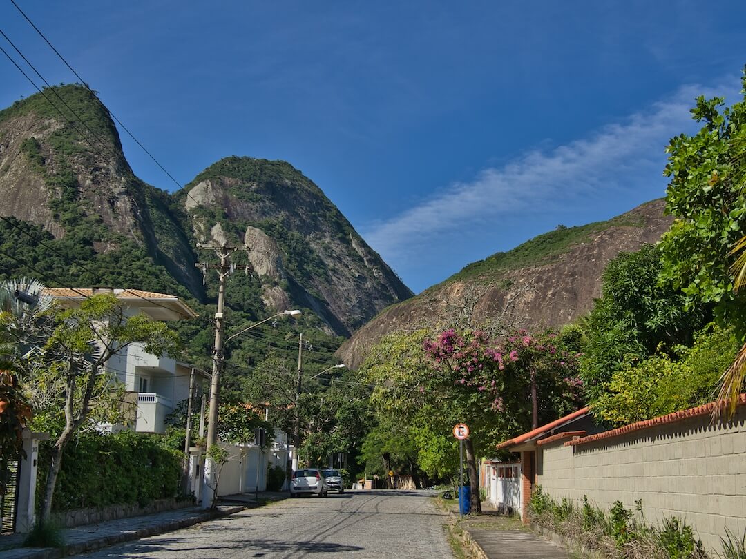 A wide cobbled street leads to a mountainous area in the background